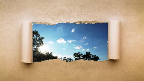 un video creativo de 4k de nubes que se mueven rápidamente en el cielo azul que son visibles a través de un agujero con bordes rasgados en viejo papel vintage retro grunge.