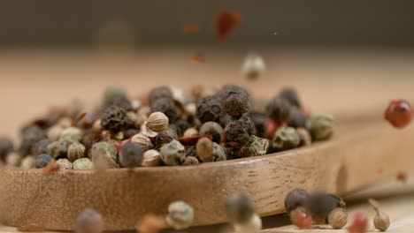 mixed peppercorns in a super slow motion. dry mix peppercorns close up.