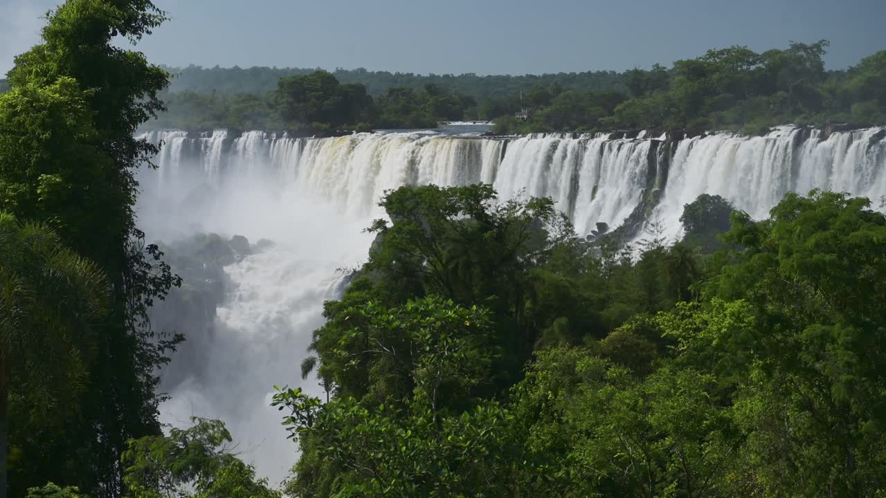 espectacular vista lejana de hermosas cascadas en el pintoresco paisaje de vegetación de la selva, increíble grupo de cascadas que caen de enormes acantilados en hermosas condiciones soleadas en las cascadas de iguazú, argentina