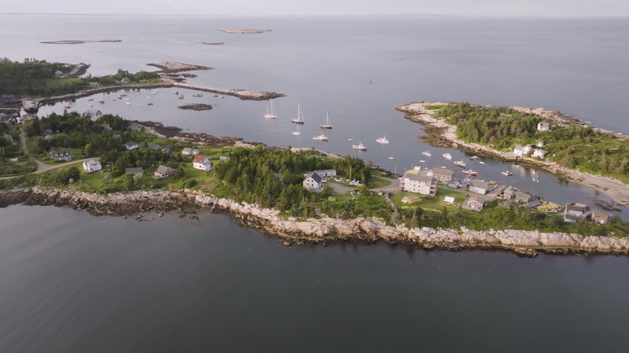 Aerial view of Matinicus Island, Maine, featuring evergreen forest, a small village, and the remote North Atlantic coastline under overcast skies.
