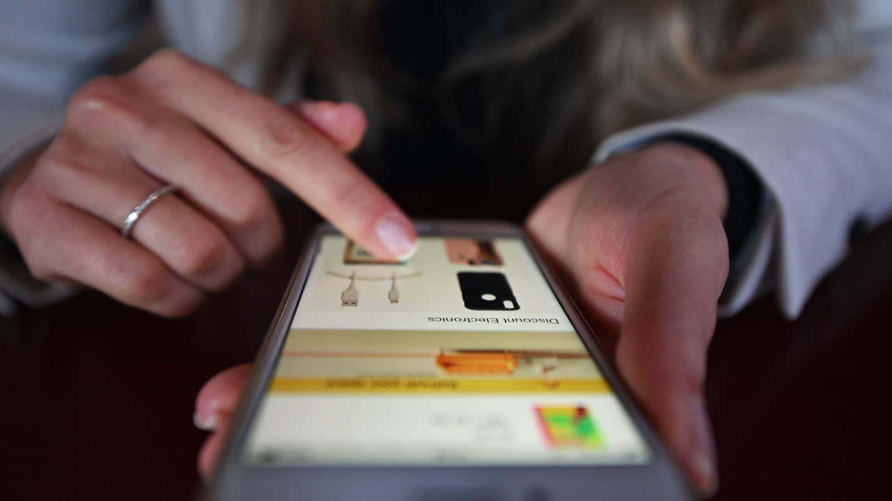 Woman working on mobile phone in a restaurant at lunch, close up