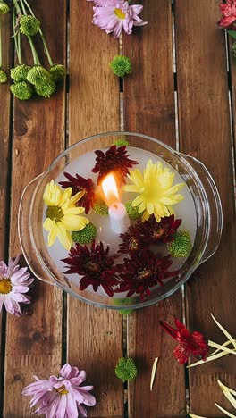 floating flowers and candle arrangement on wooden table