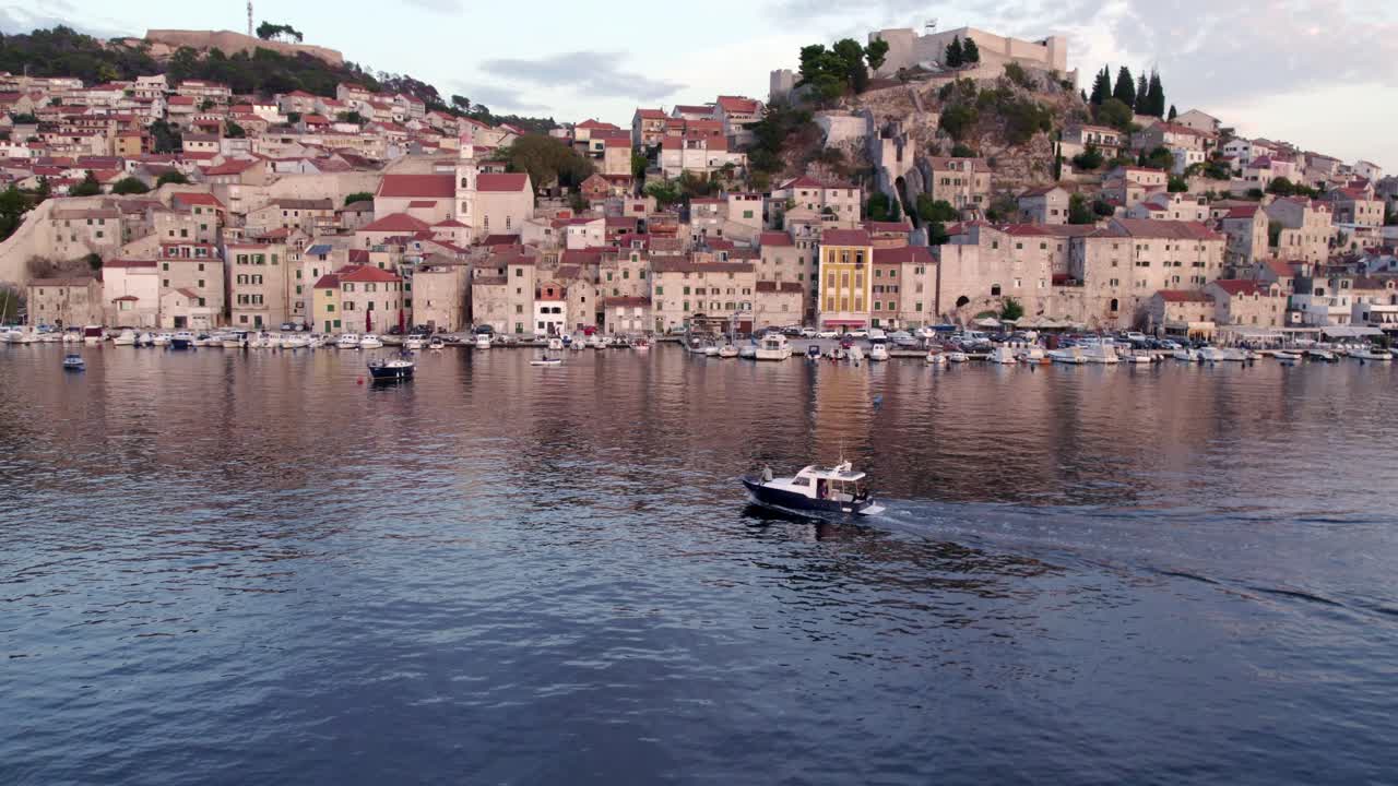 Veduta aerea di Sebenico, Croazia, città in pietra con tetti rossi sulla costa al tramonto.
