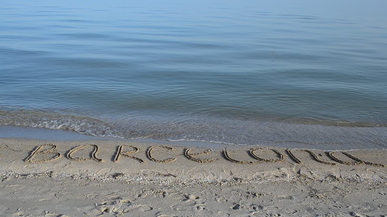 De inscriptie Barcelona in het zand. Inscriptie in het zand, het strand.