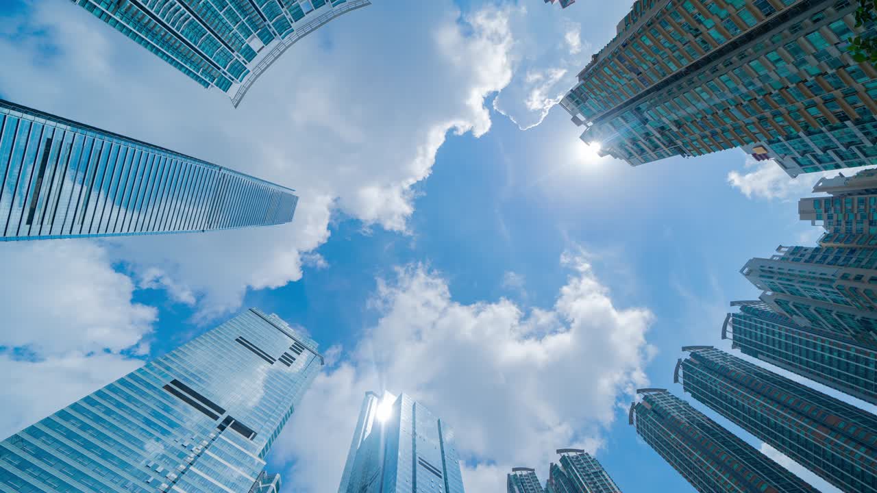 Time lapse di grattacieli per uffici e architetture nel quartiere finanziario a mezzogiorno. Sfondo di città urbana intelligente per concetti di business e tecnologia nel centro di Hong Kong, Cina.