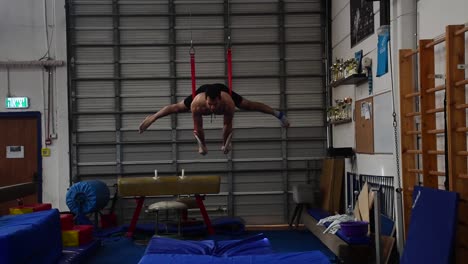 una foto fija de un tipo haciendo ejercicio en los anillos fijos de un aparato de gimnasia que es extremadamente duro en cámara lenta de 60 fps