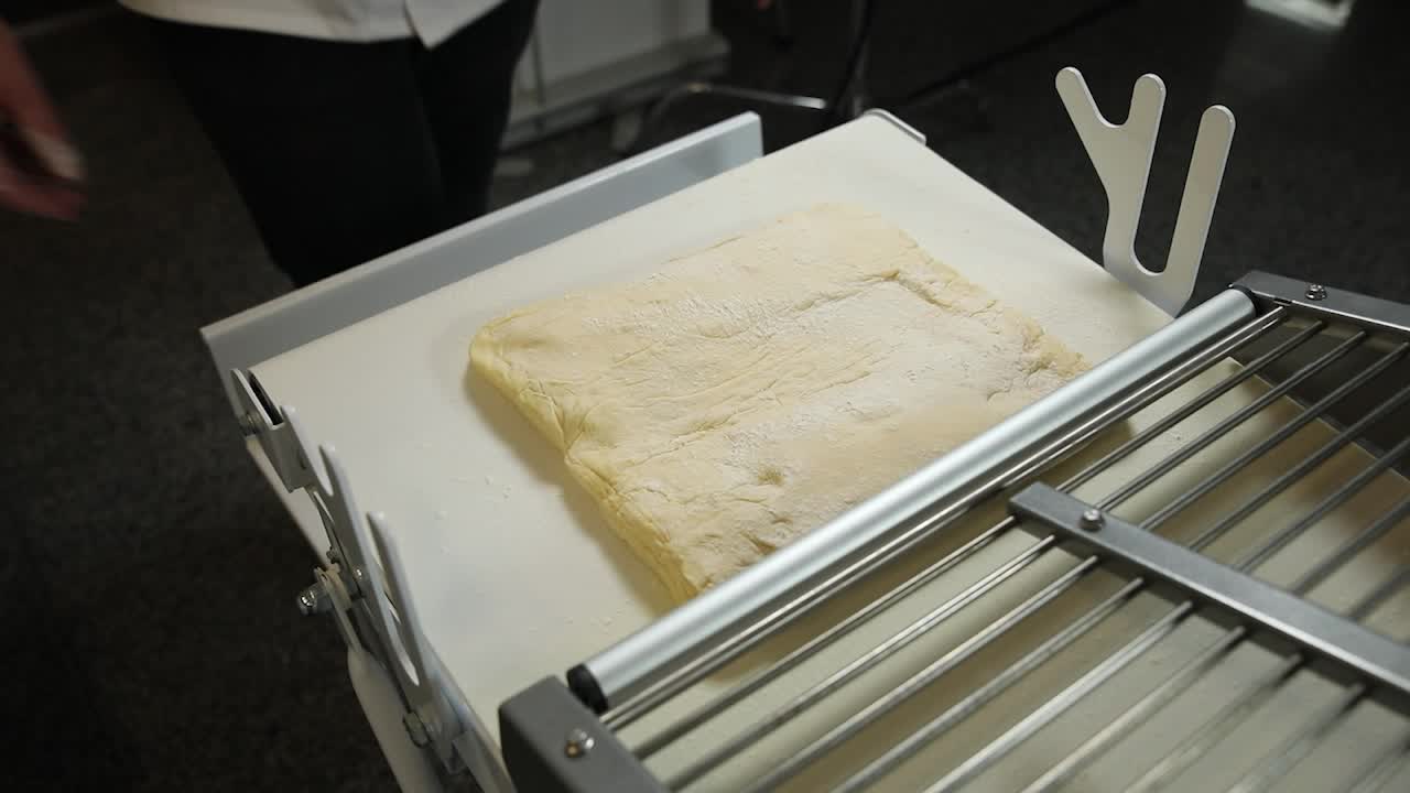Dough being processed on a conveyor belt in a bakery