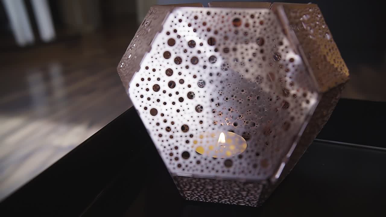 Slow pan around a candle light inside a tealight holder