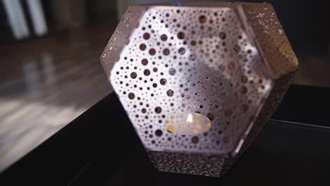 slow pan around a candle light inside a tealight holder