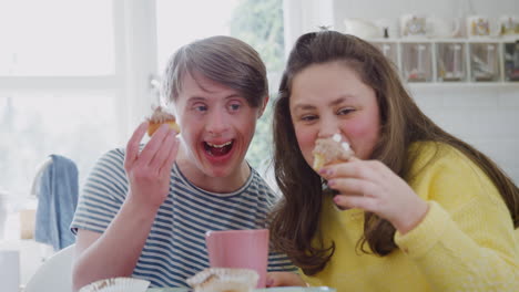 Retrato-De-Una-Joven-Pareja-Con-Síndrome-De-Down-Disfrutando-De-Té-Y-Pastel-En-La-Cocina-De-Casa