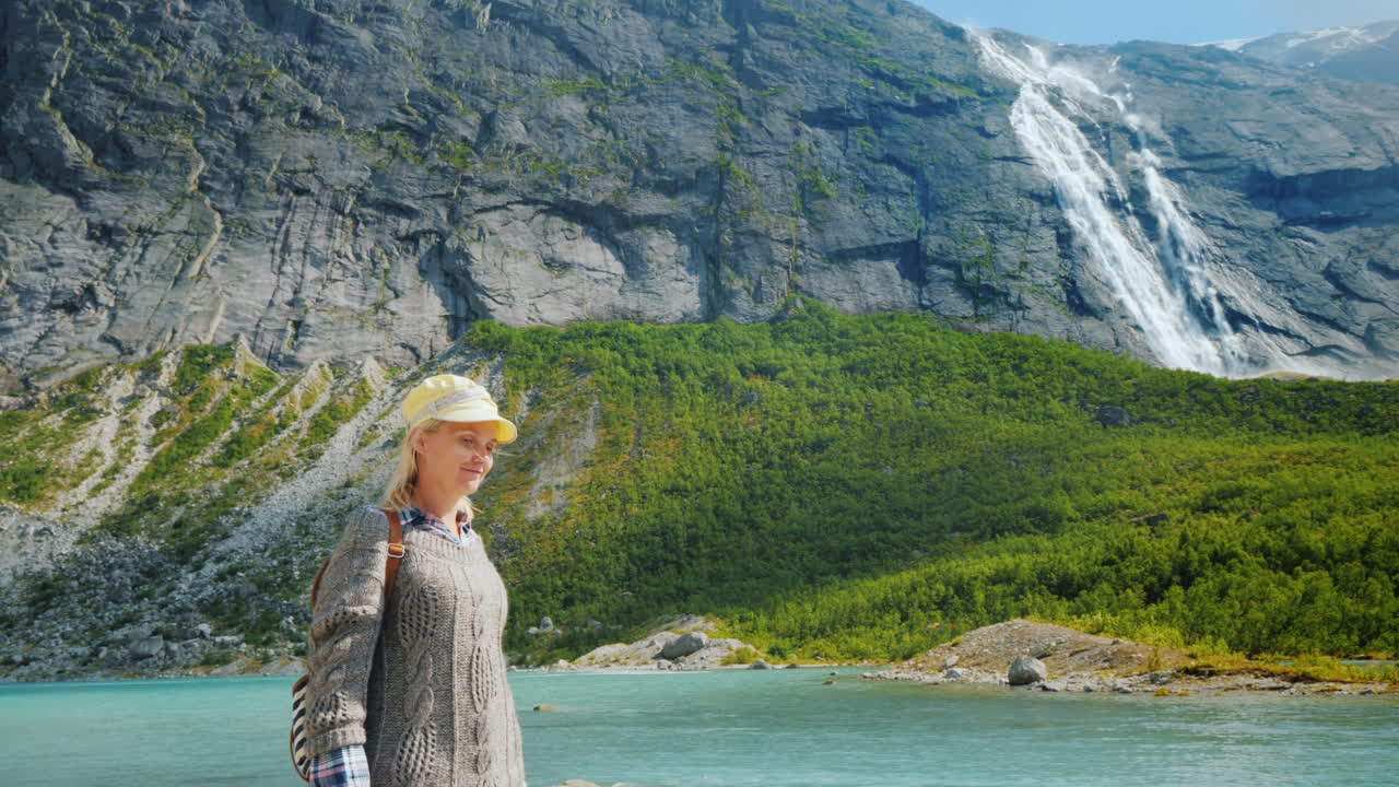 The Traveler Walks Among The Majestic Cliffs With Waterfalls And Glaciers On Top Traveling In Norway