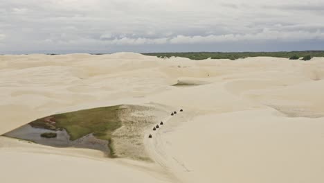 grupo en línea montando vehículos todo terreno a través de las dunas de arena de brasil