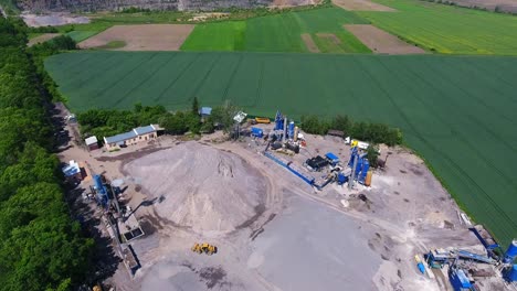 territory of a mobile asphalt plant. smoke from the enterprise chimney and embankments of rubble and sand
