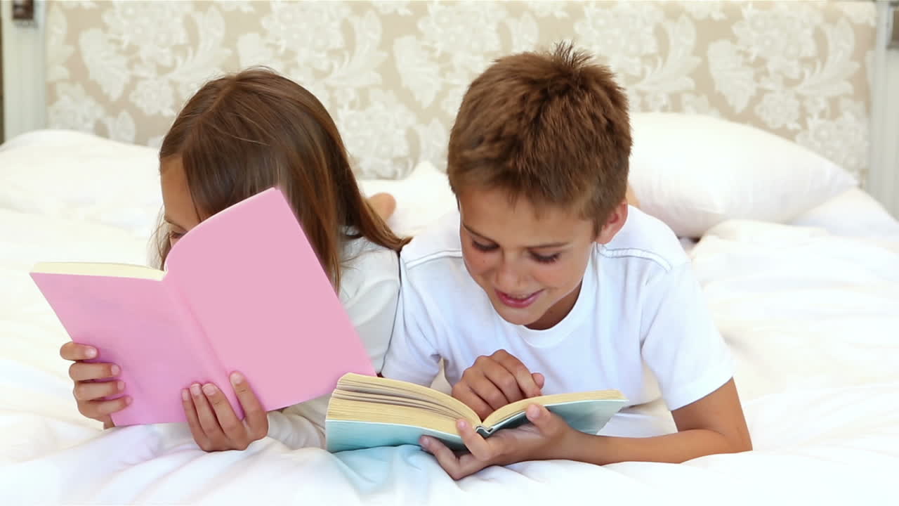 Bambini che leggono un libro sul letto