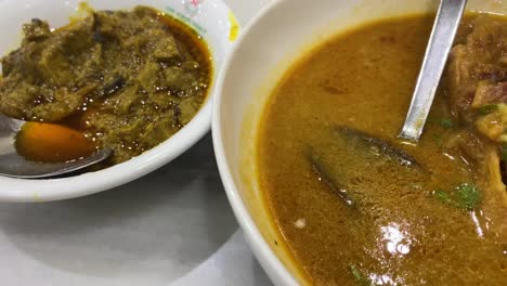 a close-up shot of liver curry, or kolija bhuna, a flavorful and spicy bangladeshi dish made with beef or goat liver and served with naan bread