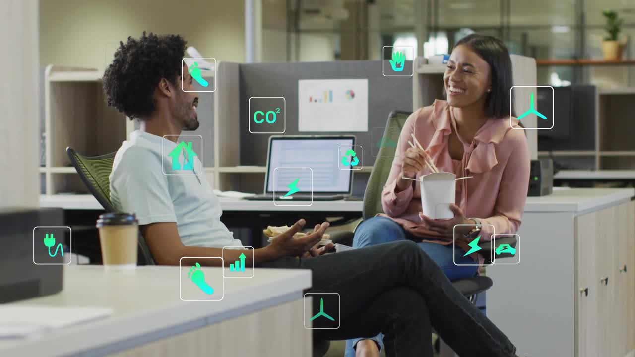 Man gesturing, causing energy icons floating around laptop while woman eating and reviewing metrics