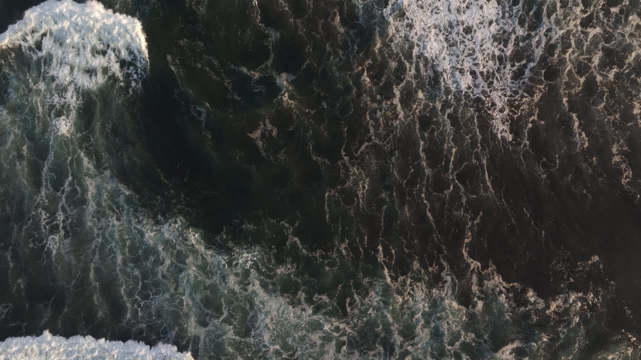 Aerial view of El Paredon beach at sunrise with warm golden light illuminating the Pacific Ocean waves and pristine sand