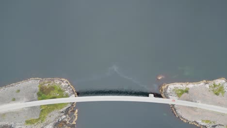 flying over car crossing a lonely bridge in norway above the ocean and between two small islands