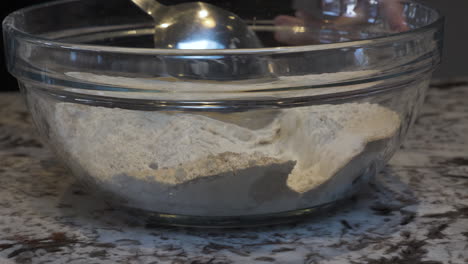 spoon mixing flour, yeast and sugar in mixing bowl