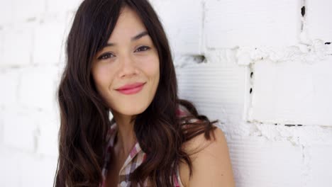 serene woman with long brown hair stares at camera