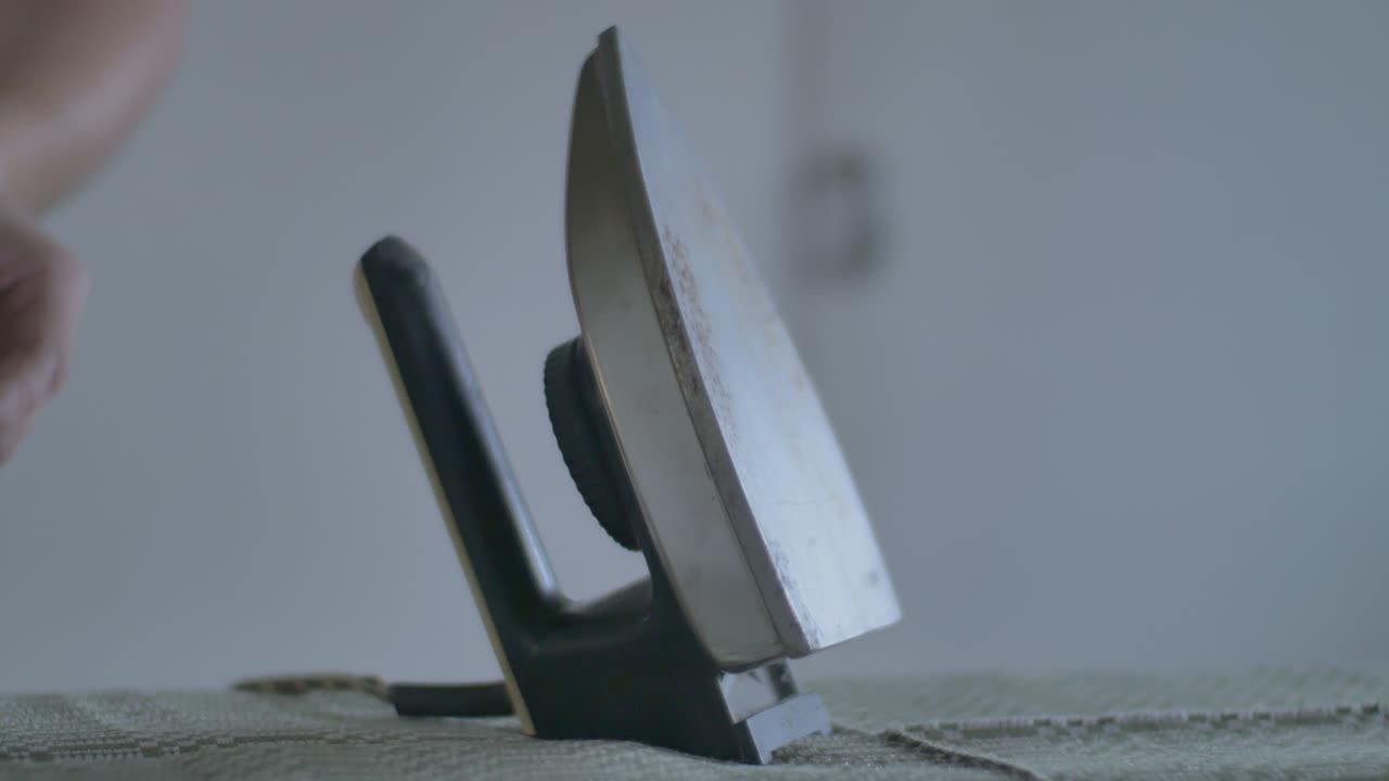 남자는 오래된 전기 빈티지 다리미로 천을 부드럽게 한다