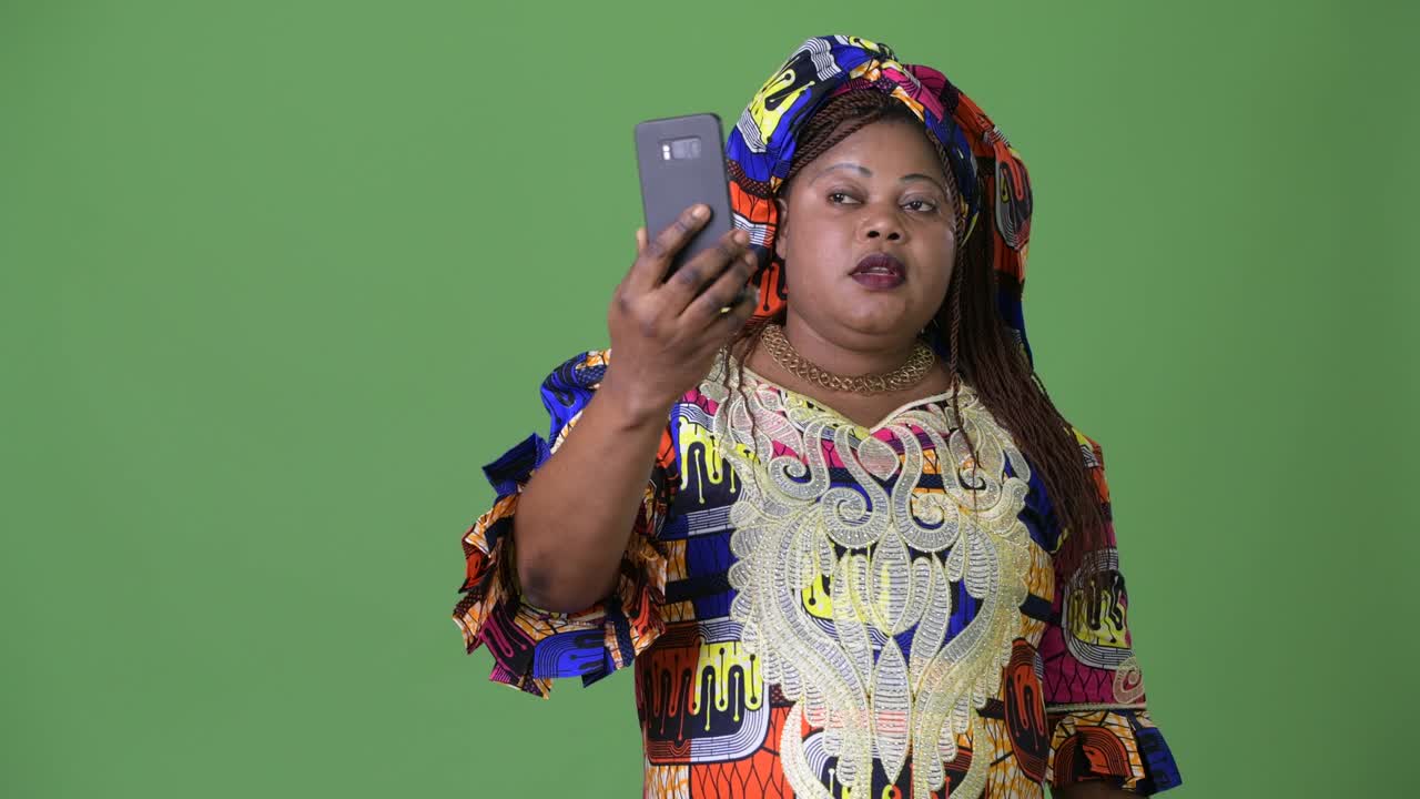 초록색 배경 에 전통 의 옷 을 입은 비만 한 아름다운 아프리카 여자