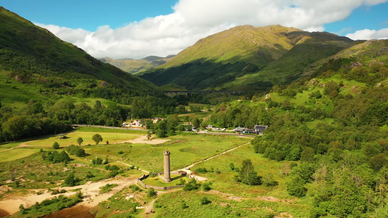 sobrevuelo aéreo del monumento de glenfinnan hacia el viaducto de glenfinnan en las tierras altas escocesas, escocia, reino unido