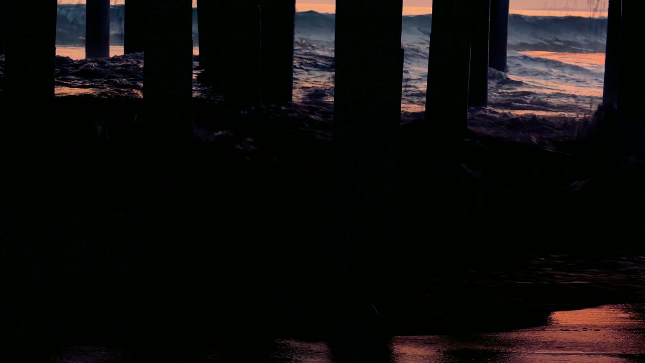 el atardecer bajo el muelle de las olas