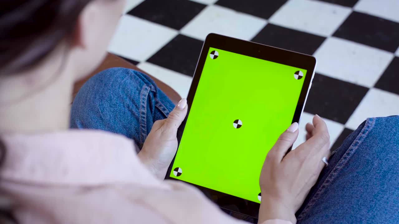 женщина использует планшет с зеленым экраном