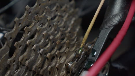 lubricante de cadena de bicicleta goteado en los enlaces en el taller de mantenimiento de cerca