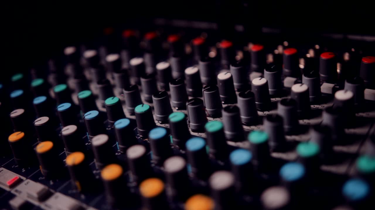 primer plano de un mezclador de sonido con botones de volumen en un estudio de música