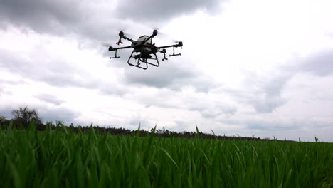 Modern-Farming-Technology,-Agriculture-Drone-Flying-Above-Green-Farming-Land-and-Crops