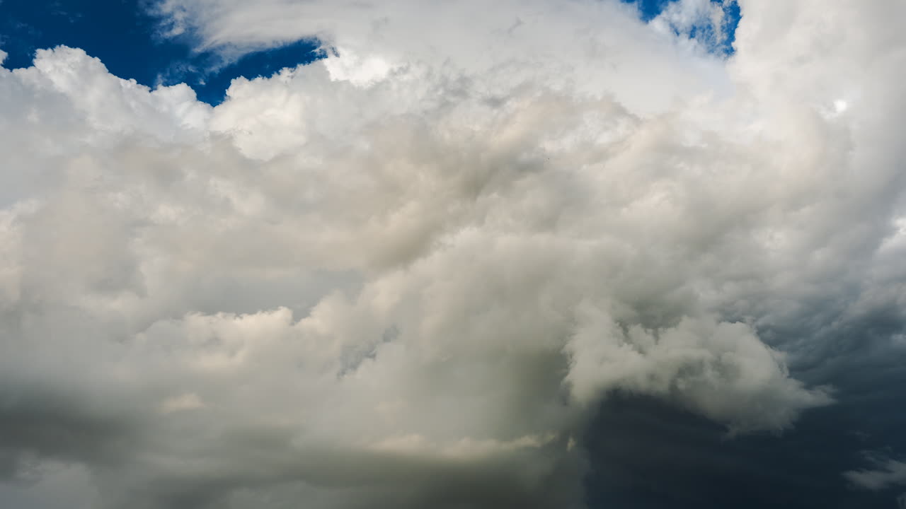 Thick grey storm clouds shifting across the sky showing evolving weather systems