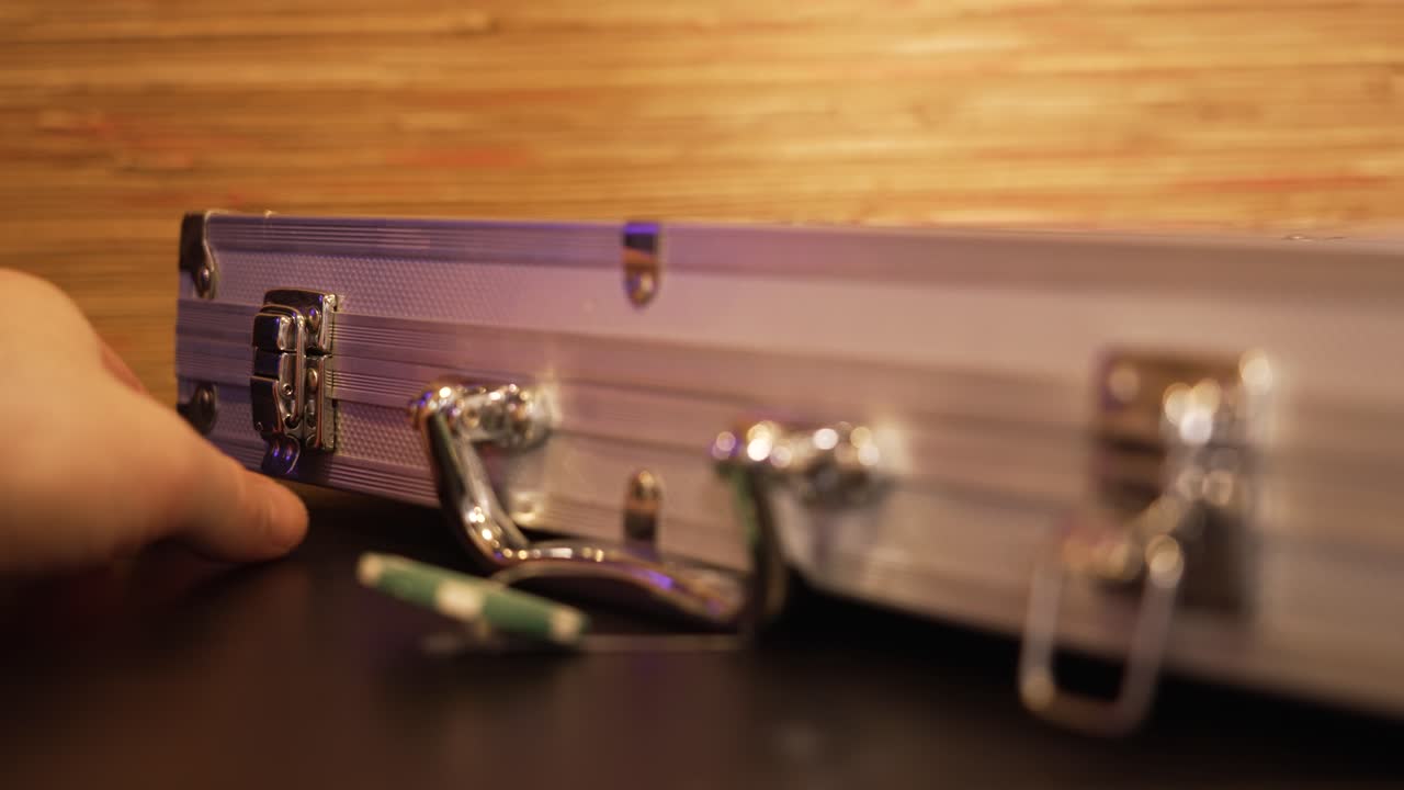 Close up of a person unlocking and then opening a case