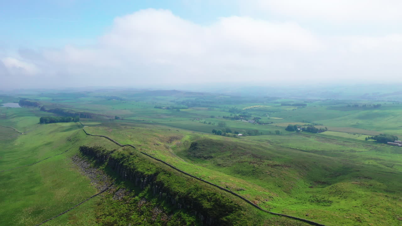 밝고 화창한 날에 하드리아누스 벽의 한 부분 위로 공중 역방향 촬영