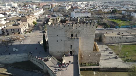 aerial pullback view of torre de calahorra, cordoba, spain. tower at end of roman bridge of córdoba