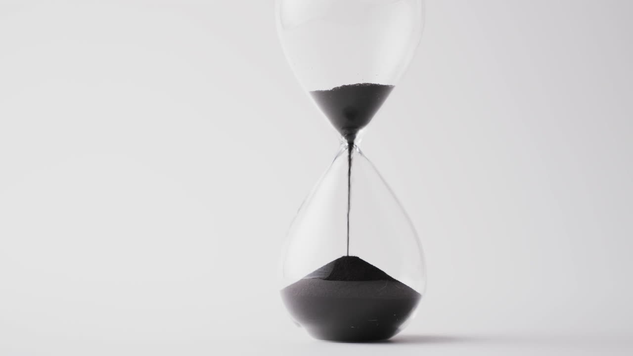 Video of hourglass with sand pouring, copy space on white background