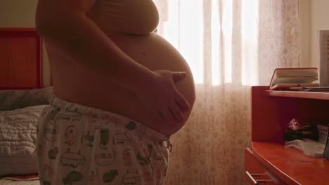 pregnant woman caressing her belly right on the skin