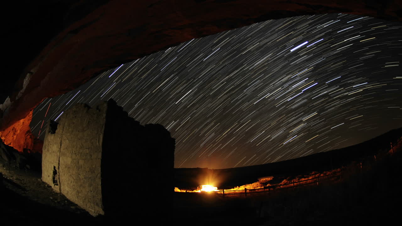 뉴멕시코 차코 문화 국립 역사 공원의 갤로 워시(gallo wash)에 있는 차코안 록 하우스 위로 타임랩스 스타 트레일 줄무늬
