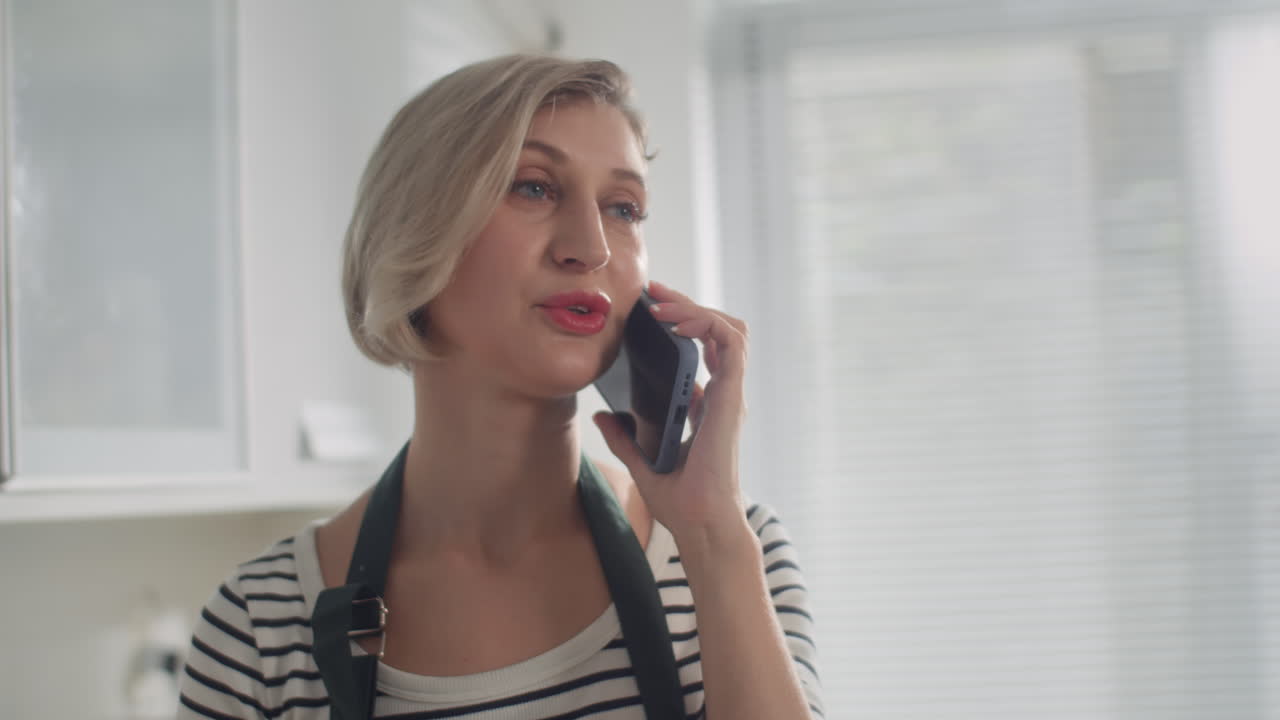 Caucasian Woman Calling on Smartphone at Kitchen