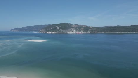 Aerial-view-of-a-industrial-marina-and-the-Troia-Peninsula,-in-Setubal,-Portugal