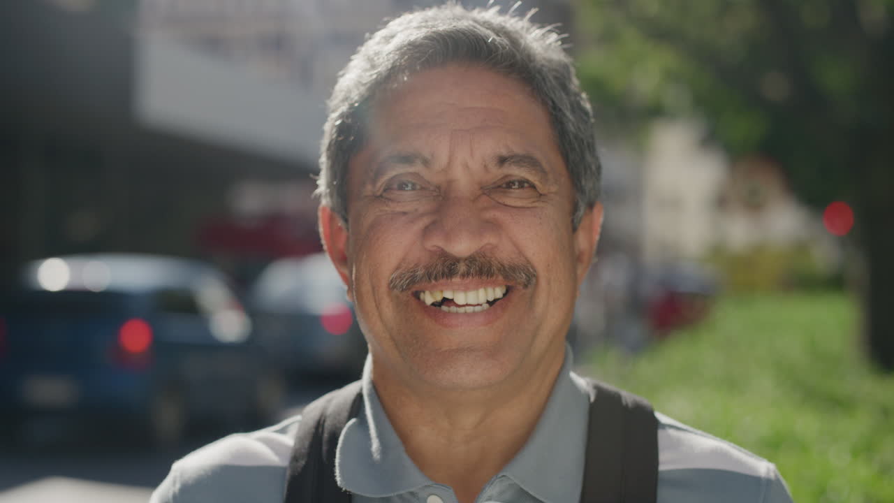 retrato de un hombre maduro de raza mixta sonriendo feliz disfrutando de un exitoso estilo de vida de jubilación en la soleada calle de la ciudad.