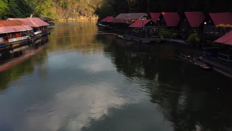 Un-Impresionante-Dron-Disparó-Volando-Rápido-Más-Allá-De-Un-Encantador-Pueblo-Flotante-Y-Sobre-Un-Río-En-La-Jungla-Del-Parque-Nacional-Sai-Yok-En-La-Provincia-De-Kanchanaburi-En-Tailandia