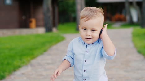 cool 1 year old kid plays with the keys to the car speaks as on the phone as a small businessman 4k