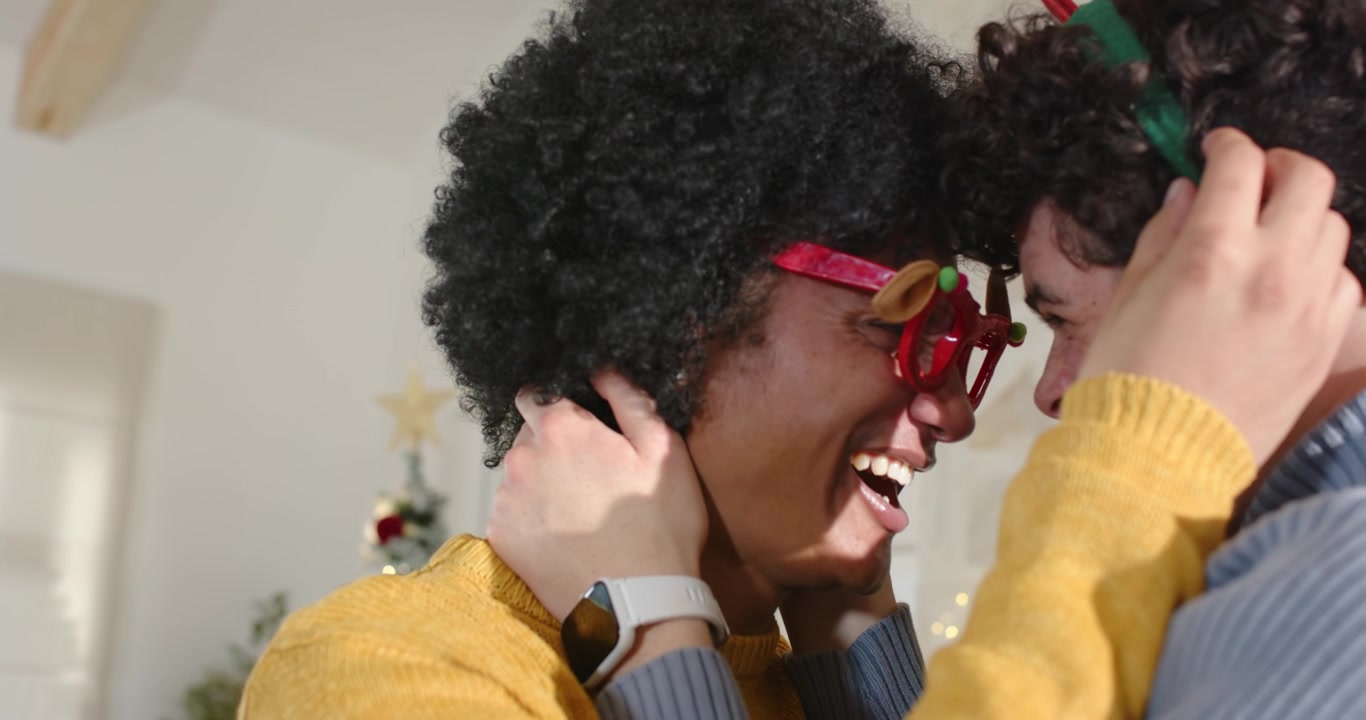 African American men fixing red glasses, pressing foreheads, sharing joy in living room