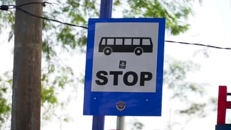 Bus-stop-road-sign-against-the-backdrop-of-trees-and-sky