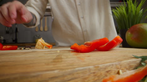 el chef cortando pimientos rojos
