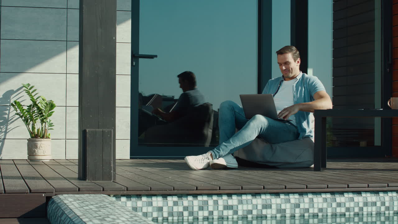 hombre relajado hablando en línea en una computadora portátil afuera. hombre feliz hablando en un cuaderno.