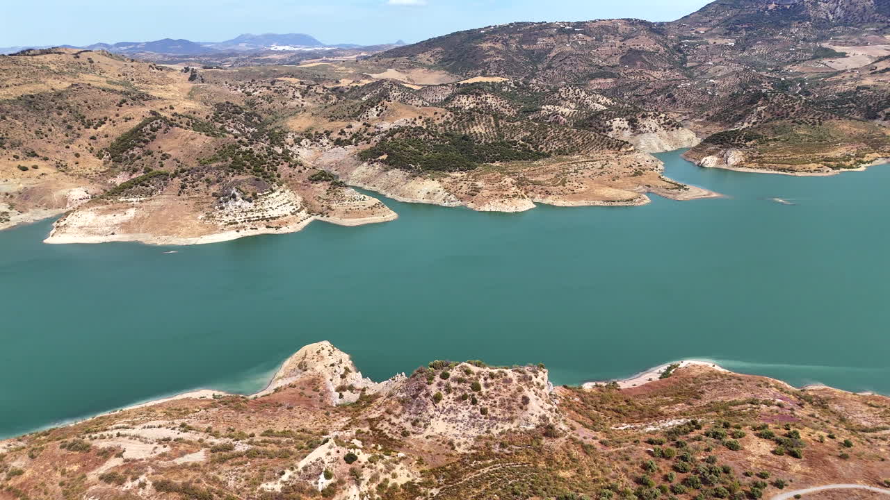 Aerial drone footage of Zahara-El Gastor reservoir surrounded by mountains and hills in Andalusia, southern Spain
