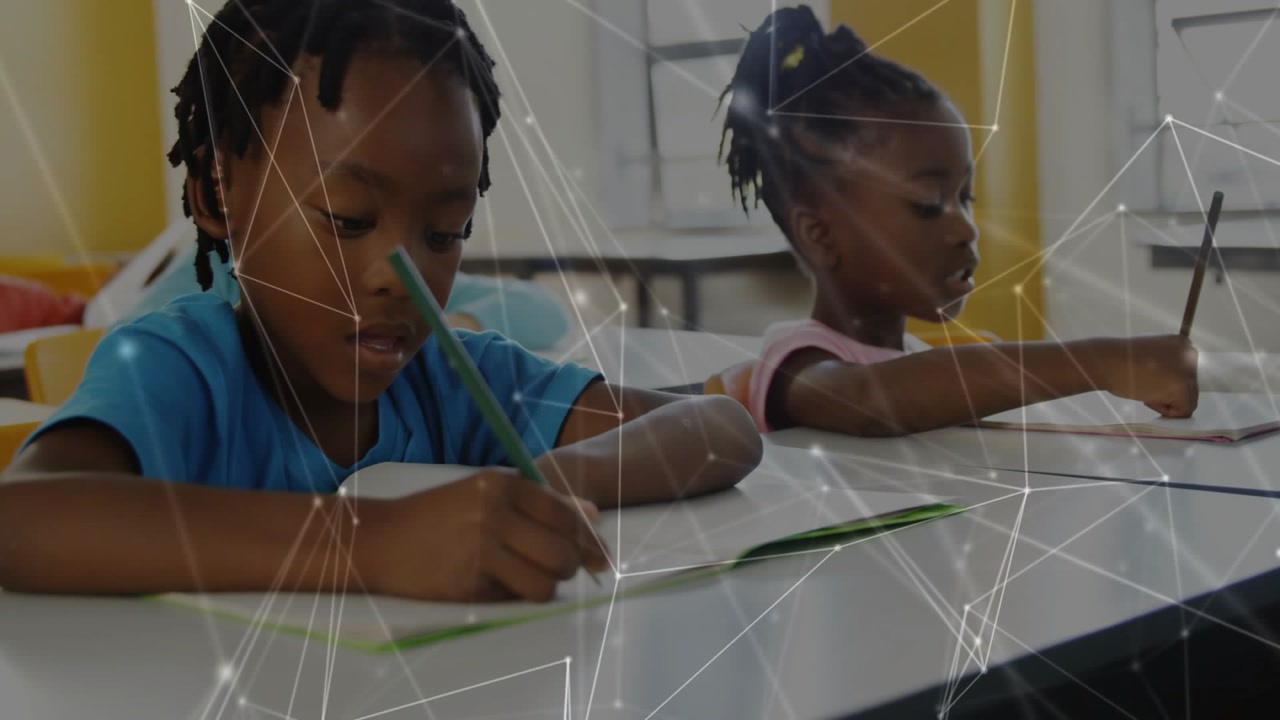 Boy leaning forward writing, girl bringing pencil down, network overlay linking notes for education